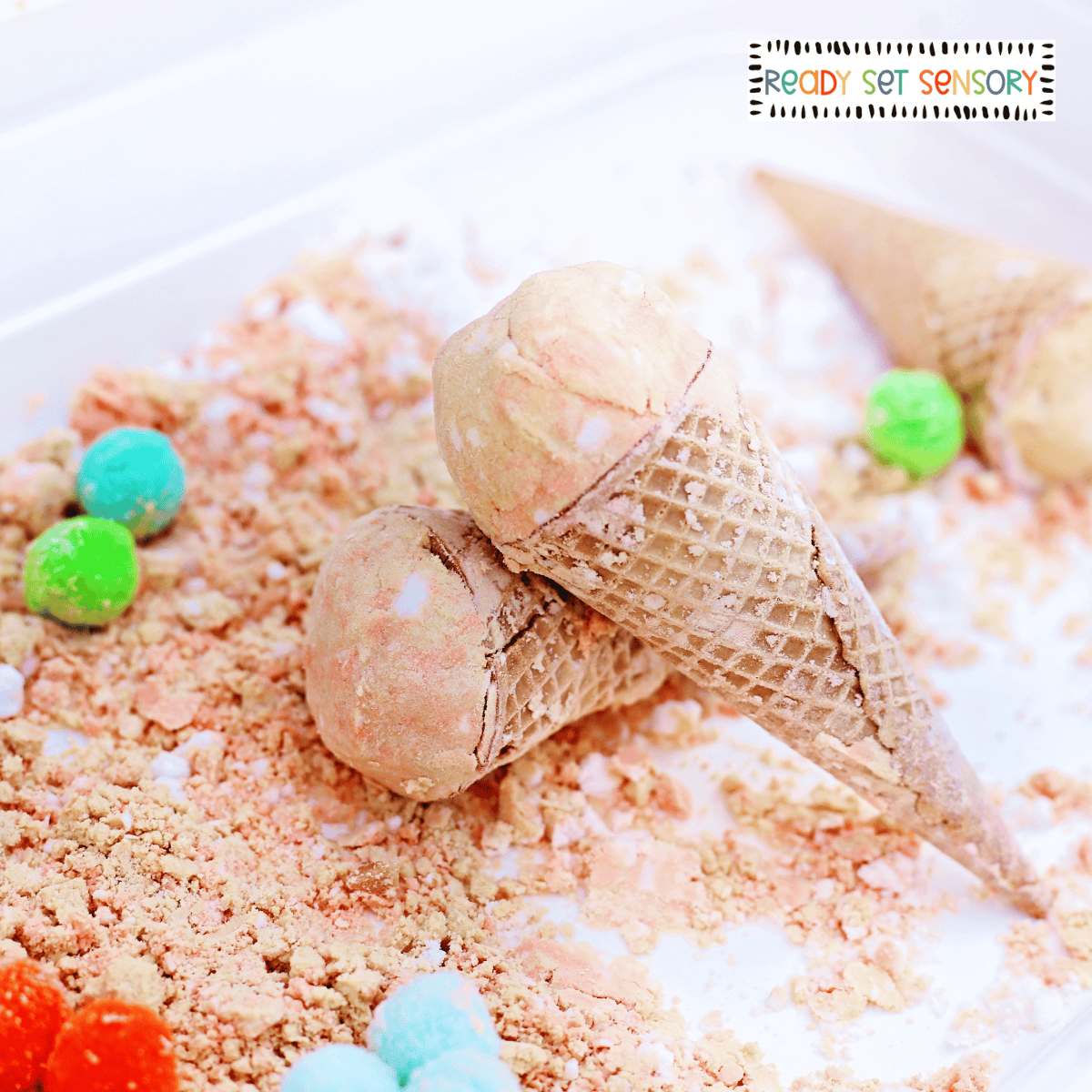 Cloud dough ice cream sensory bin with waffle cones and colorful pom poms