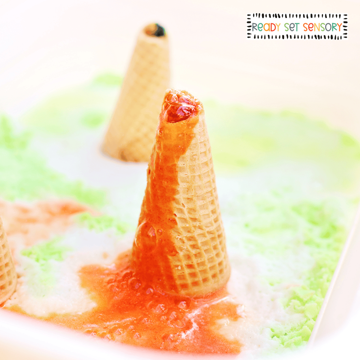 Baking soda volcano eruption in fizzy sensory bin