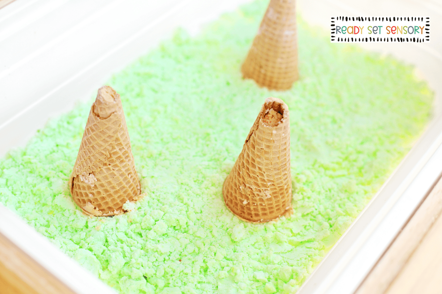 Fizzy volcano sensory bin with waffle cone volcanoes
