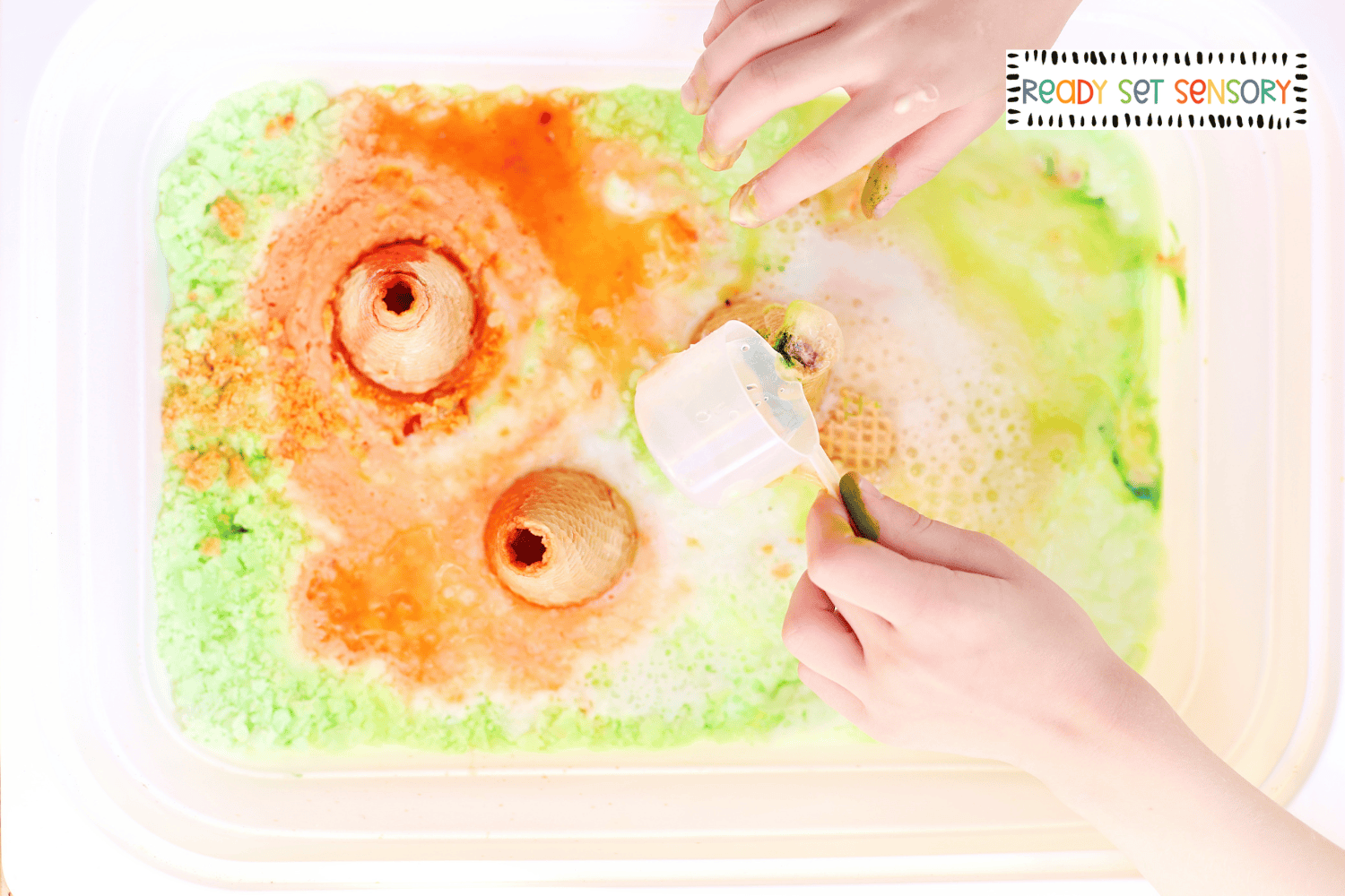 Child exploring fizzy volcano sensory bin eruption