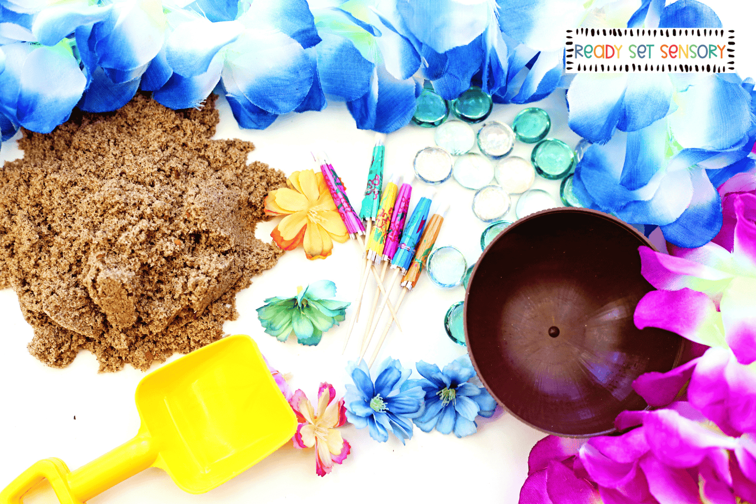 Tropical sensory bin supplies with sand, flowers, and scoops