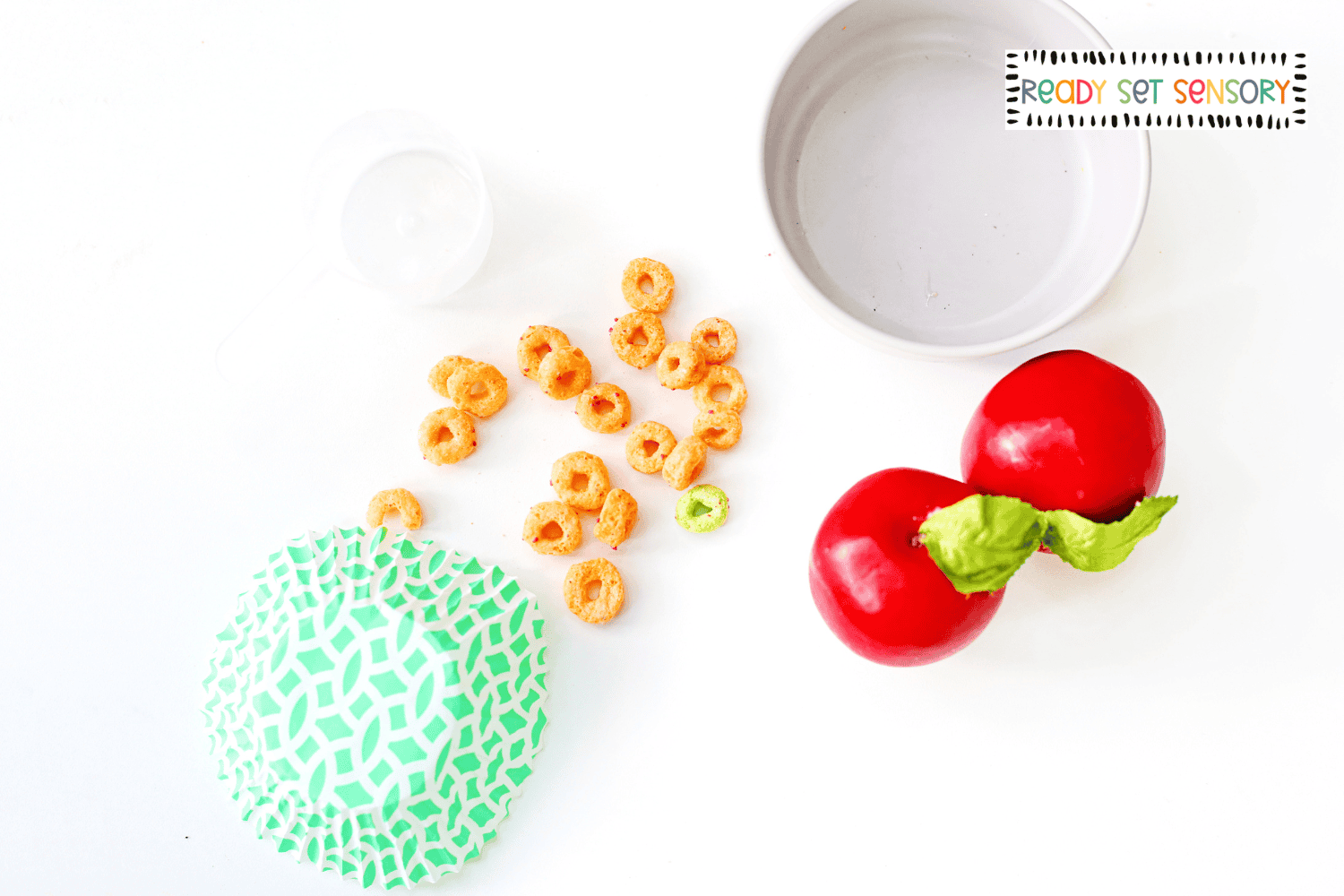 Apple Jacks sensory bin supplies with cereal, apples, cupcake liner, and container for toddler sensory play