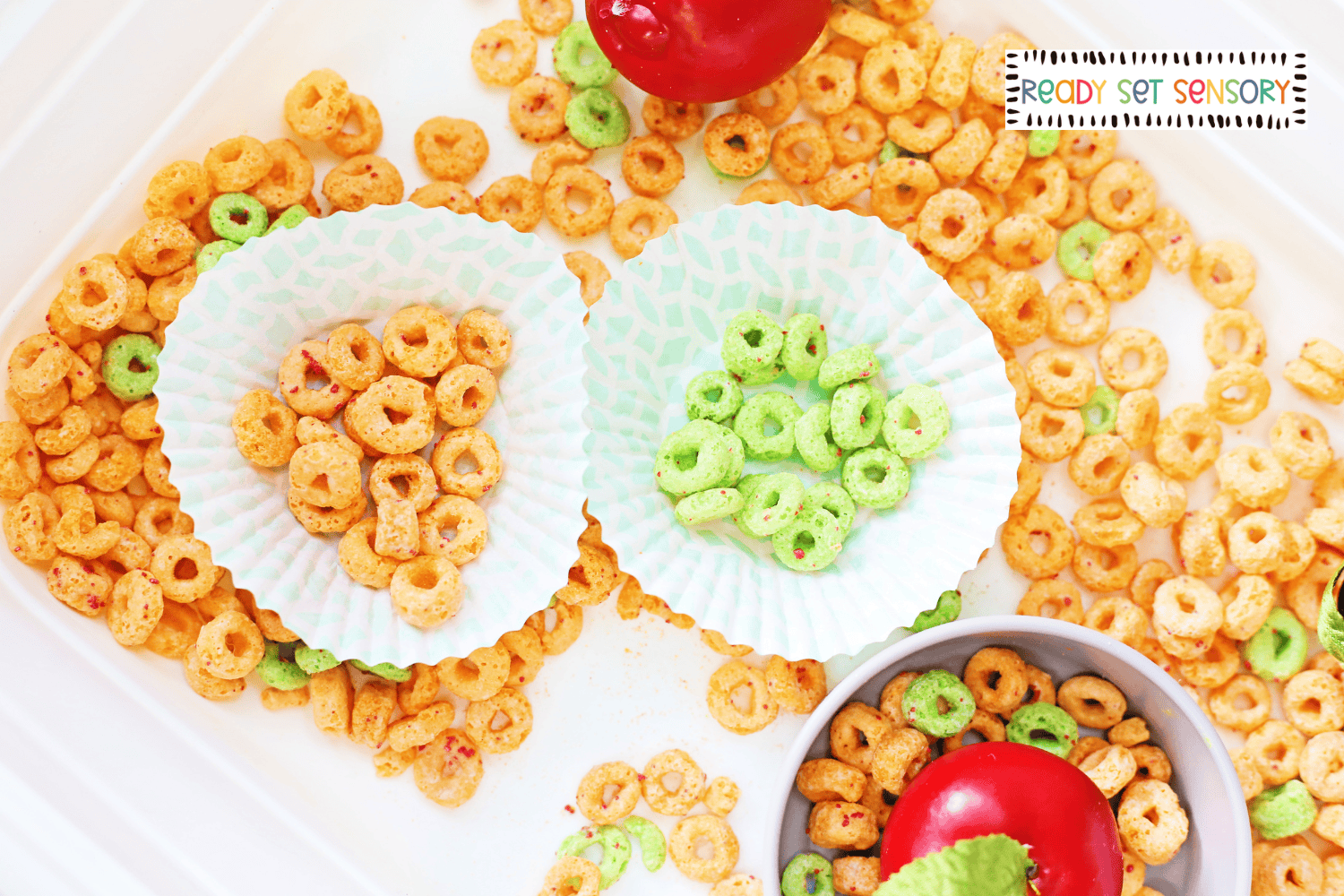 Apple Jacks sensory bin color sorting activity with green and orange cereal pieces
